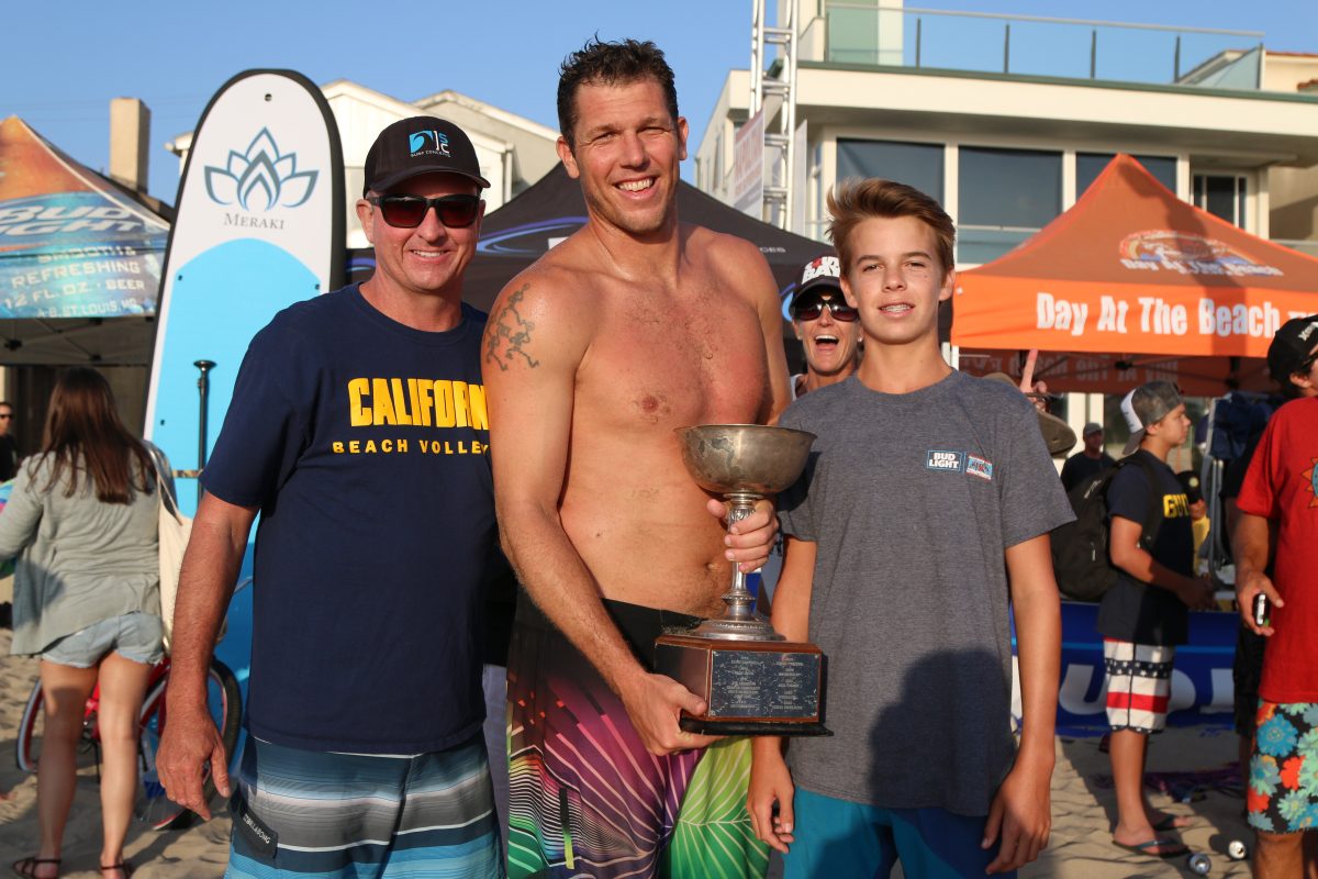 Laker head coach Luke Walton with the Lee Campbell MVP Award after winning the Hermosa Beach 16th Street Labor Day Weekend Volleyball Tournament, on after losing six times in the finals. Walton is flanked by Kevin and Luke Campbell, the son and grandson of tournament co-founder Lee Campbell. Photo by Kevin Cody